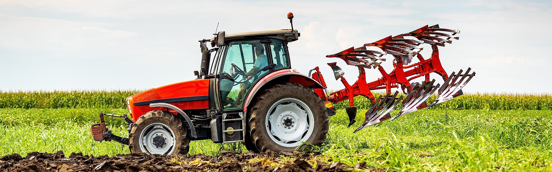 Roter Traktor auf Feld Landwirtschaft