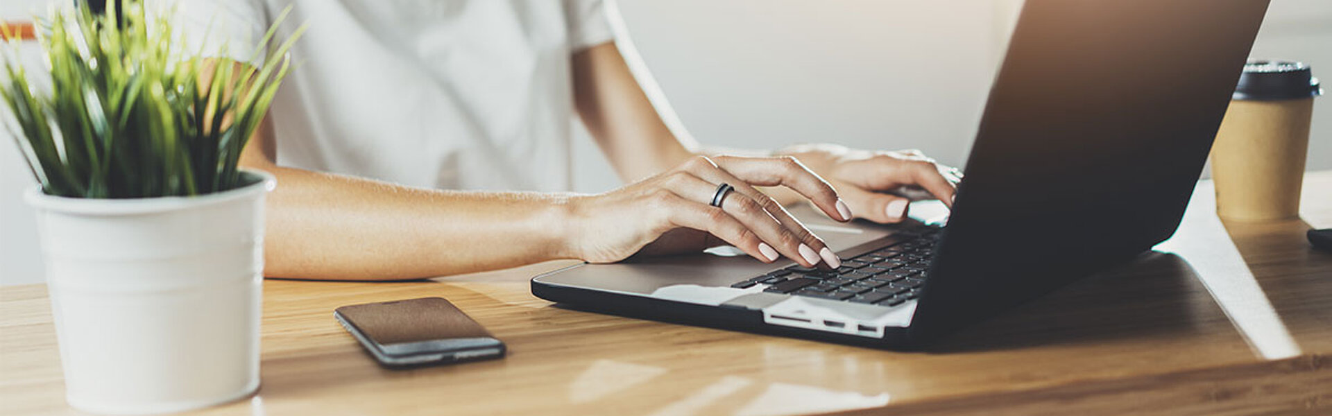 Neustarthilfe für Soloselbstständige - Eine Übersicht Frau sitzt an einem Schreibtisch und arbeitet auf einem Laptop