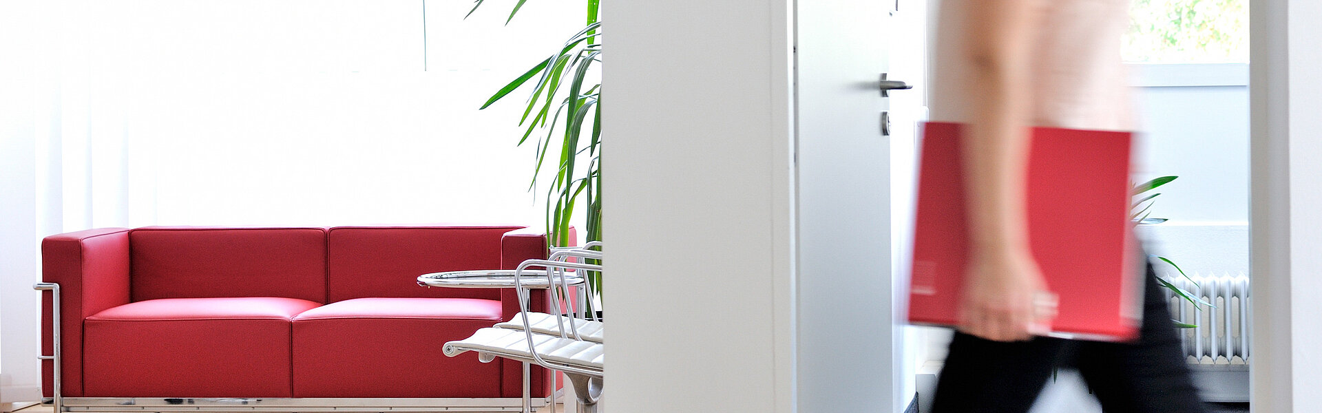 Frau im Büro mit ECOVIS Ordner rot unter dem Arm