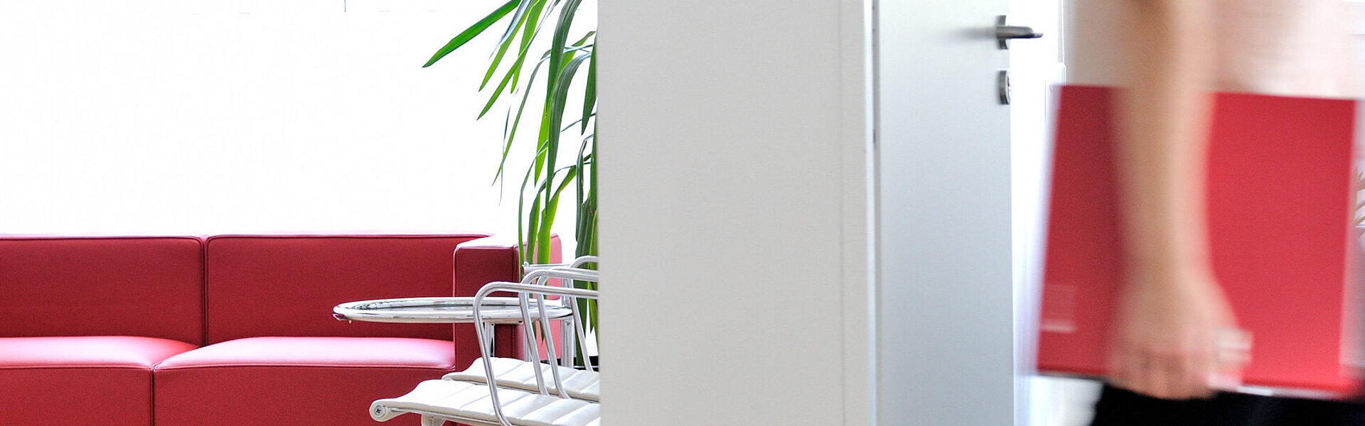 Frau im Büro mit ECOVIS Ordner rot unter dem Arm