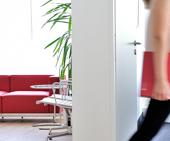 Frau im Büro mit ECOVIS Ordner rot unter dem Arm