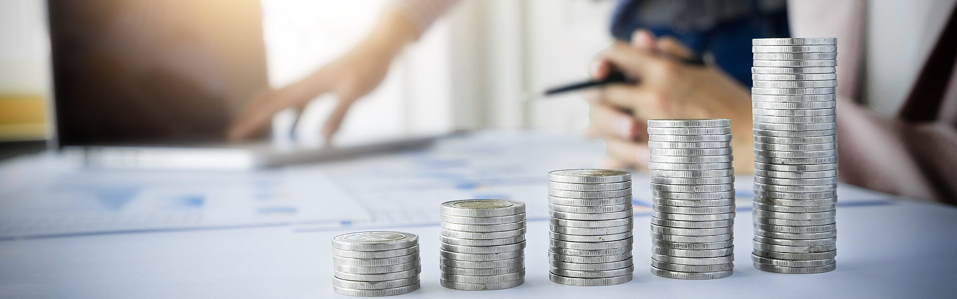 Inflationsausgleichsprämie: letzte Chance für steuerfreie Zahlungen bis Ende 2024 Geldmünzen gestapelt am Schreibtisch