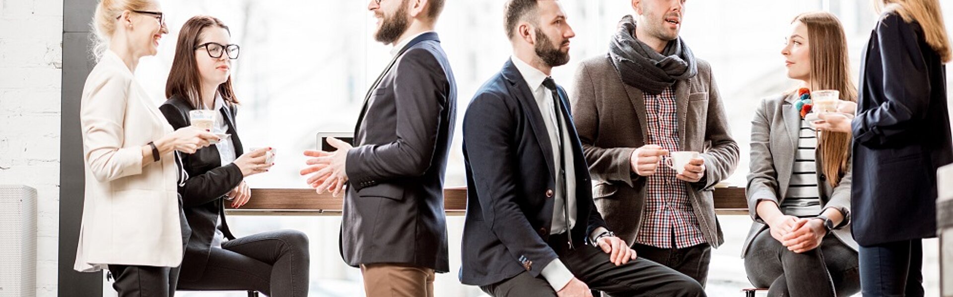 No-Show Kosten von Firmenveranstaltungen Casual gekleidete Menschen unterhalten sich auf einer Business Veranstaltung